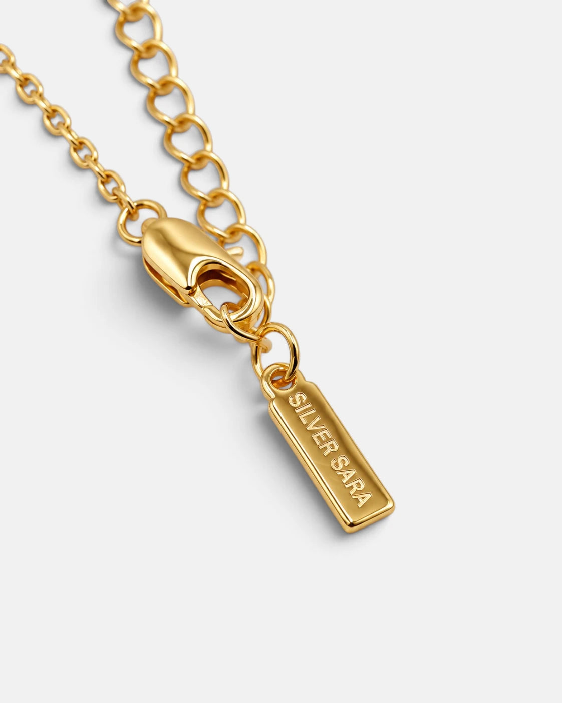 Gold-plated extension chain and Silver Sara logo tag on the Everlasting Star Necklace